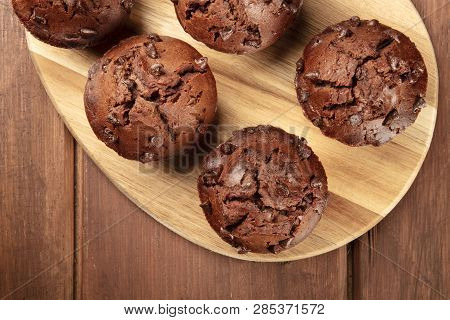 A Closeup Photo Of Chocolate Chip Muffins, Shot From Above On A Dark Rustic Wooden Background With A