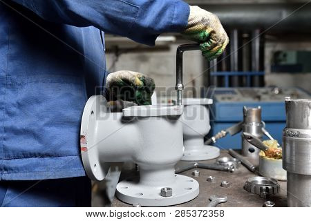 The Base For The Valve Is Mounted On An Iron Table For Assembly At The Factory And The Worker Instal