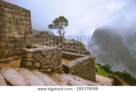 Amazing view of majestic Machupicchu temple landscape covered with fog on the background