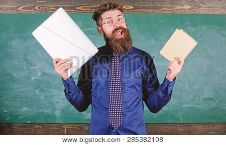 Stay Modern With Technology. Teacher Bearded Hipster Holds Book And Laptop. Modern Technologies Bene