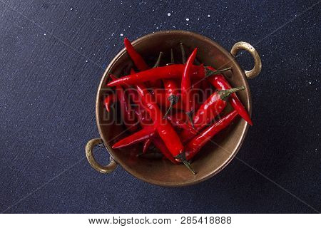 Red Spisy Small Chili Peppers In Cooper Bowl On Dark Background.