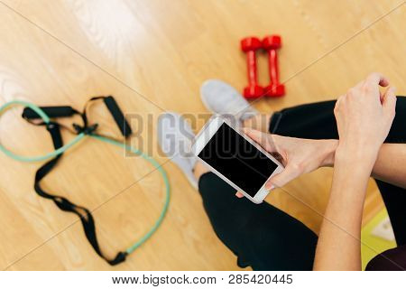 Woman In Fitness Clothing Using Smartphone. Fitness And Diet, Gym And Workout Concept