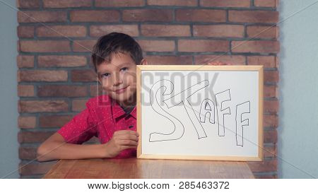 Portrait Little Boy Showing Whiteboard With Handwriting Word Staff. Schoolboy Throw Out Documents. P