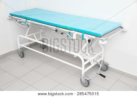 Medical Trolley Bed Near Wall In Modern Clinic