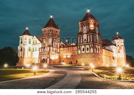 Mir, Belarus. Mir Castle Complex In Evening Night Illumination Lighting. Famous Landmark Under Blue 