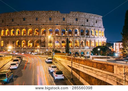 Rome, Italy. Colosseum Also Known As Flavian Amphitheatre In Evening Or Night Time. Night Traffic Li