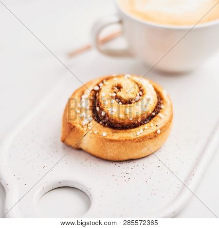 Freshly Baked Cinnamon Roll With Spices And Cocoa Filling And Coffee Or Cappuccino With Latte Art On