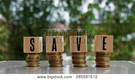 Save Text On Wooden Block On Top Of Coins Stack