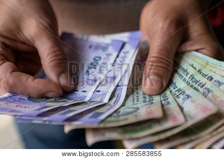 Indian Business Man Counting Cash Banknotes Of Newly Launched 100 Rupees. Money Counting Concept For