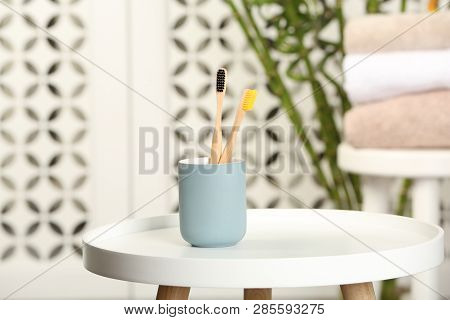 Holder With Bamboo Toothbrushes On Table In Room