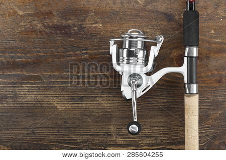 Rubel Reel And Fishing Rod On A Wooden Background. View From Above