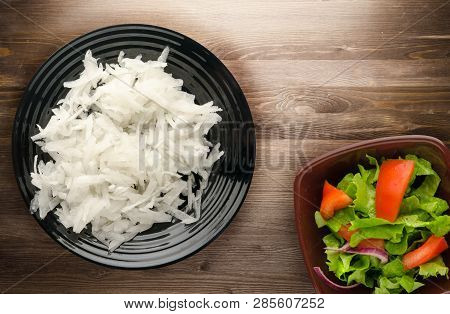 Daikon On A Wooden Background. Daikon On A Plate
