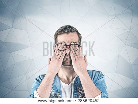 Casual Man Covering Eyes With Hands, Gray Wall