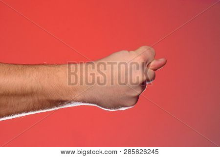 Mans Hand With A Figs Sign Close-up Is Isolated On A Red Background
