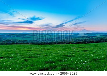Evening Time Dusk Sunset Over Fields Of Grasss And Trees In Cornwall