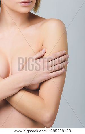 Partial View Of Nude Girl Covering Breast, Isolated On Grey