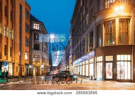 Riga, Latvia. Row Of Bicycles For Rent At Bike Parking On Valnu Street In Lighting In Night Illumina