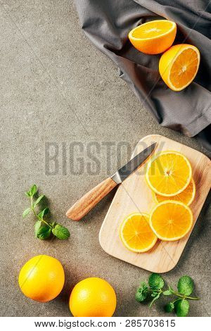 Cliced Oranges On Cutting Board With Knife And Cloth