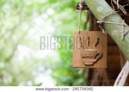 Wood Crafted Into Hot Coffee Cup Sign Hanging With A Big Bamboo Tree