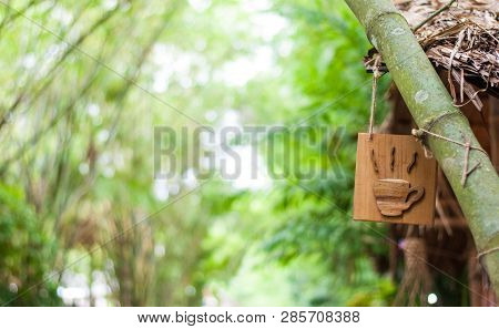 Wood Crafted Into Hot Coffee Cup Sign Hanging With A Big Bamboo Tree
