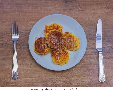 Cottage сheese Pancakes With Fried Crust With With Fork And Knife On Wooden Background