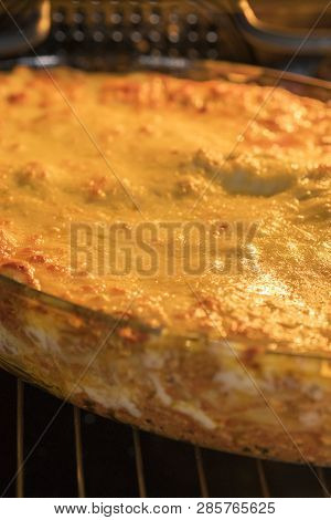 Dish Of Lasagne Cooking Inside Oven. Baking Tray With Spinach Lasagna In Oven. Ertical Photo