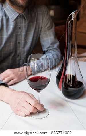 Man Sommelier Presenting An Empty Elegant Phallic Glass Decanter
