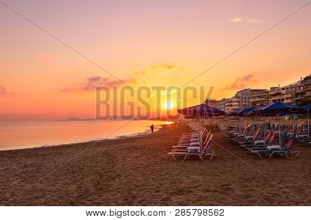 Morning On The Beach Near The Sea. Sun Chairs On Sandy Beach At Sunrise, Crete, Retimno. Beautifull 