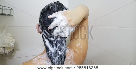 A Girl Washing Her Head In A Shower View From The Back With Hand Up