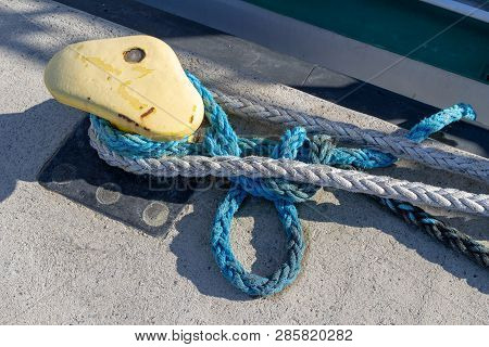 Ship Mooring Rope Moored On The Bollard. Moored Boat In The Port.