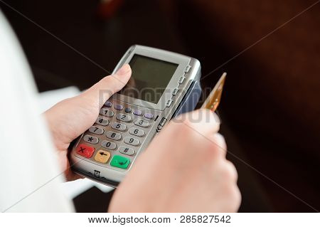 Hand Swiping Debit Card On Pos Terminal