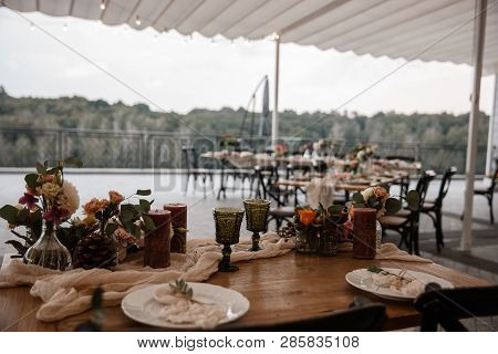 A Lot Of The Decorations And Some Empty Plates Are Standing On The Table. Restauraunt Terrace At The