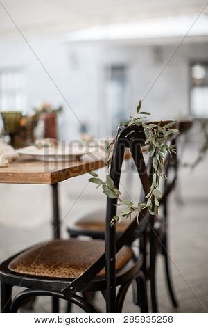 A Wreath Of Leaves Is Hanging On A Chair. Restauraunt Terrace At The Background.