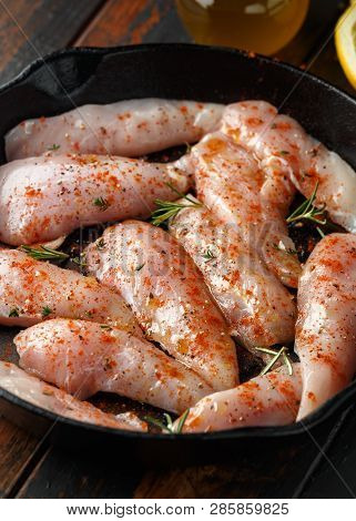 Raw Chicken Breast Mini Fillets In Rastic Cast Iron Skillet, Frying Pan With Herbs And Sea Salt