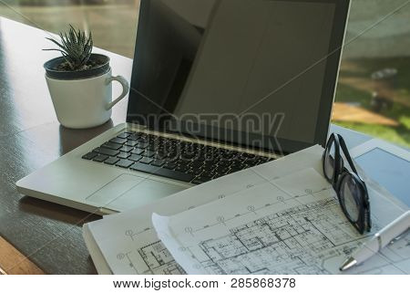 Work Area With Laptops And Communication Devices, Including Work Documents And Glasses And Small Pot