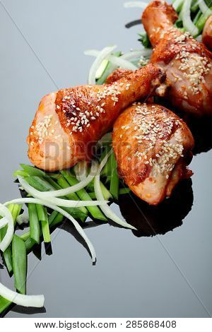 Roasted Chicken Legs On The Miror Background. On The Green Onion.copy Space