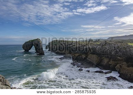 Cliffs And Canyon In Town Of Llanes Villahormes, The Islet Known As Castro De Las Gaviotas In Asturi