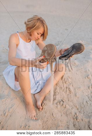 Girl Sitting Sand Shakes Out Shoes Conceptual