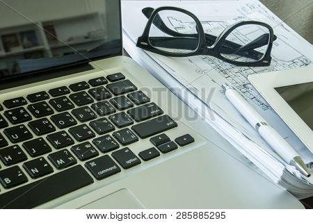 The Top View Of The Desk With Laptops And Communication Devices, Including Glasses And Work Document