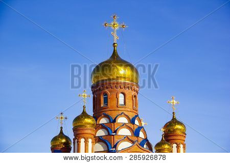 Gilded Orthodox Cross On The Dome Of The Church Against The Blue Sky