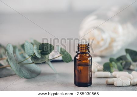 Eucalyptus Essential Oil And Fresh Leaves, White Capsules Pills On The Stone Board