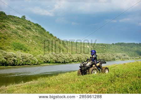 The Boy Is Traveling On An Atv.