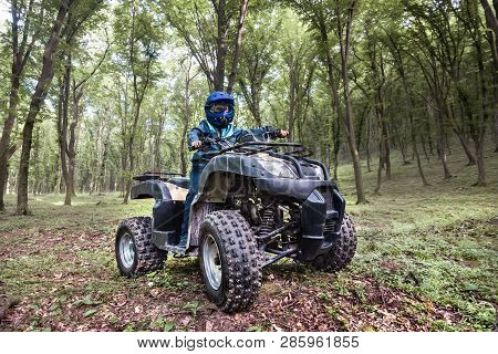 The Boy Is Traveling On An Atv.