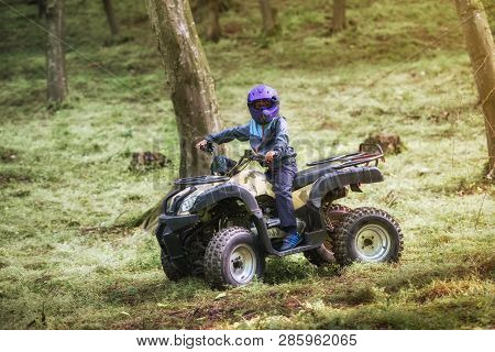 The Boy Is Traveling On An Atv.