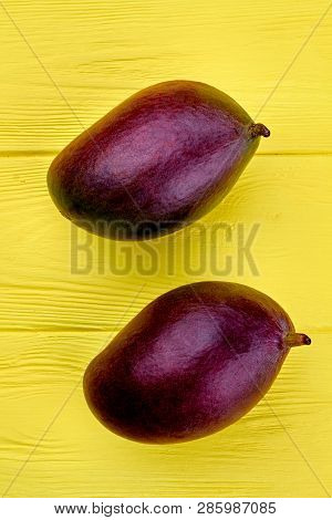 Two Fresh Mango Fruits, Top View. Underripe Organic Mango On Light Wooden Background.