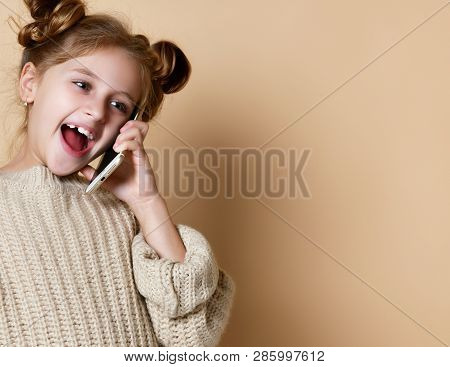 Little Girl In Oversized Sweater Happily Chatting On By Cell Phone With His Classmates Nude Beige Ba