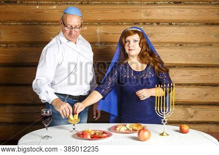 A Jewish Family, A Husband In A Kippah And A Wife In A Cape On Their Heads In Rosh Ashana Eat Challa