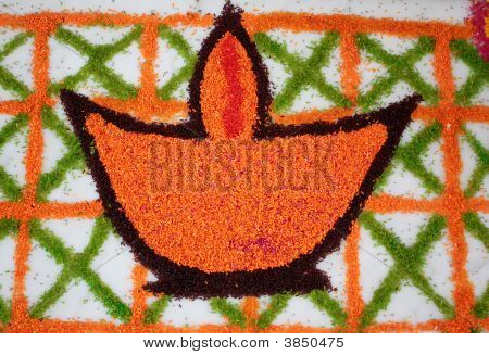 Rangoli di una lampada (Diya) fatto da riso colorato