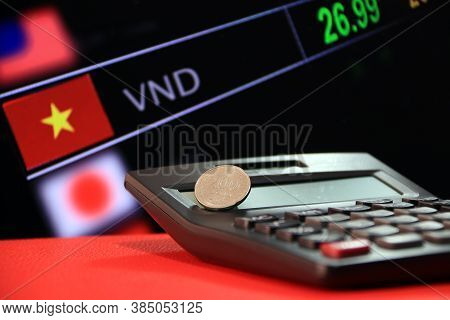 Two Hundred Vietnam Dong Coin On Reverse (vnd) On Black Calculator And Red Floor With Digital Board 