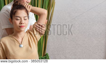 Thai Masseuse Doing Massage For Woman In Spa Salon. Asian Beautiful Woman Getting Thai Herbal Massag